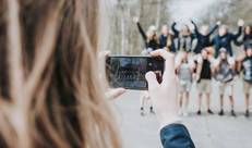 Een Chiroleidster neemt met haar gsm een foto van Chiroleden