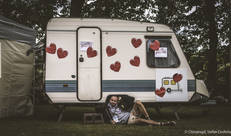 Man in Chirokledij voor caravan met hartjes op
