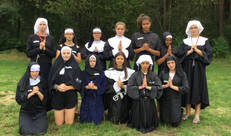 Groepsfoto in biddende pose, in religieuze kledij