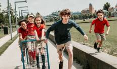 De foto die op de voorpagina van de beleidsnota 2022-2025 staat. Verschillende kinderen en jongeren lopen samen richting de camera. 