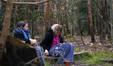 Leidsters zitten met dekentje buiten in het bos