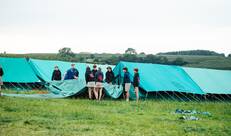 Leden zetten een tent op.