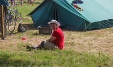 Jongen zit op de grond voor een tent