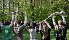 Vijf jongeren houden een touw vast boven hun hoofd 