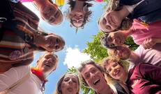 Negen mensen van onderaanzicht in een kring op de Pride parade in Brussel 2026