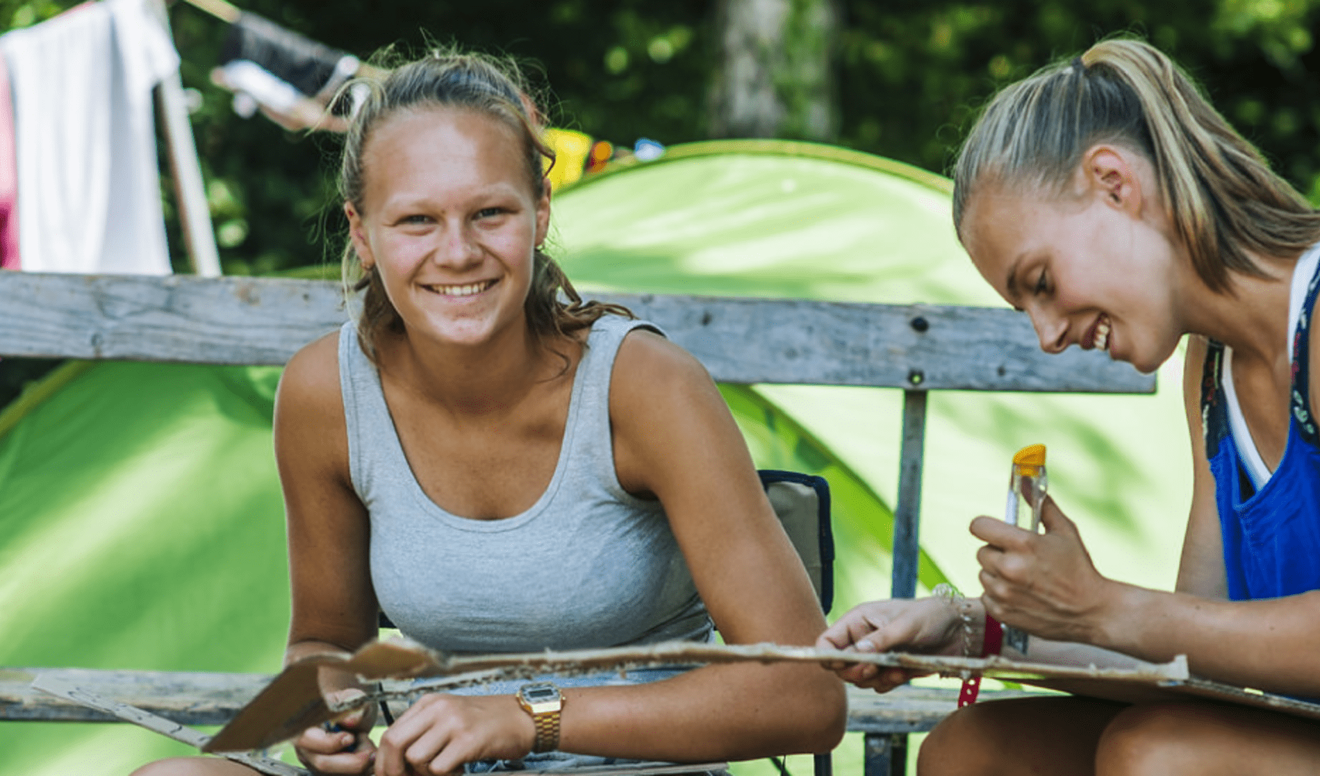 Twee Chiroleidsters die in kampeerstoel zitten om spel voor te bereiden