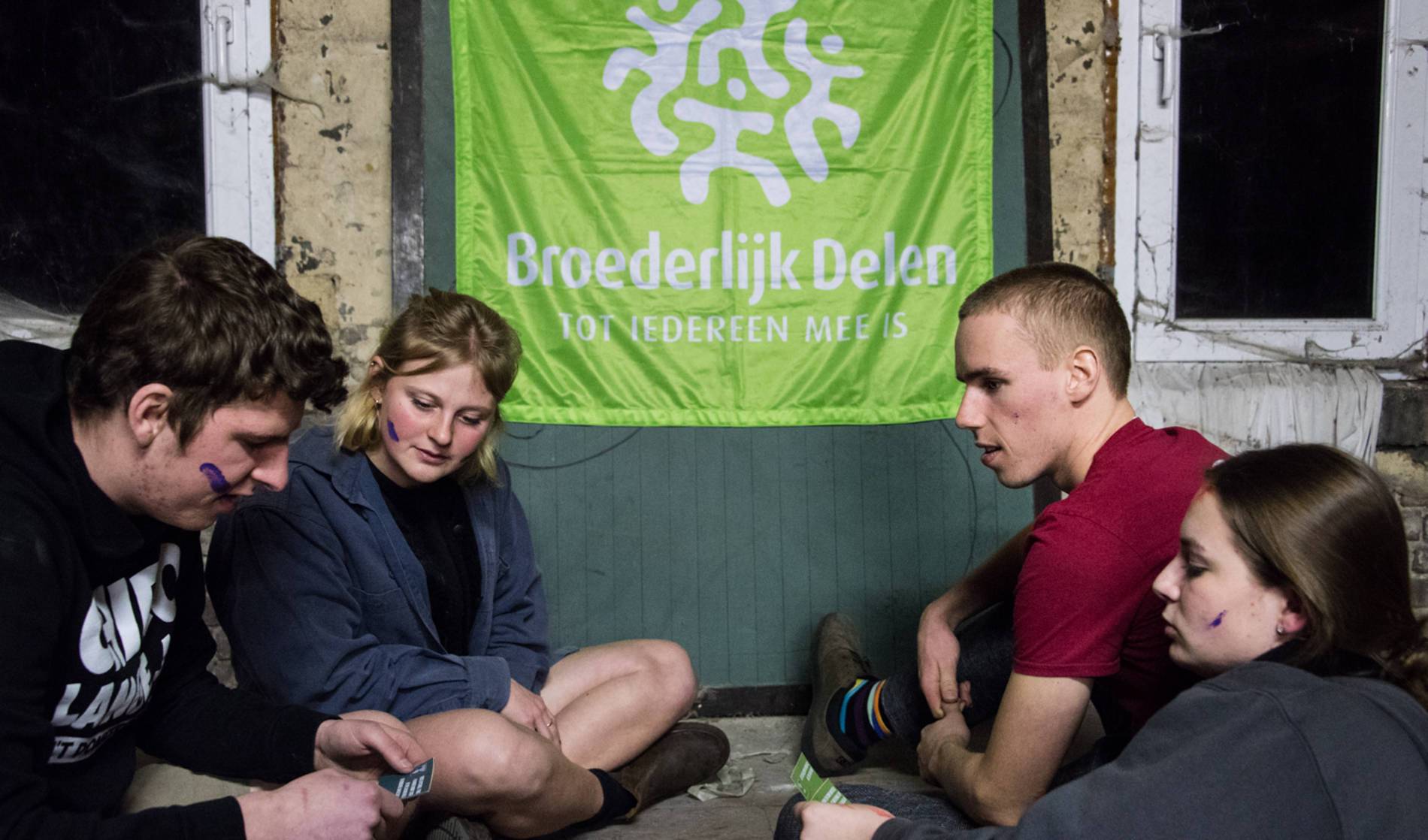 mensen bij vlag van broederlijk delen