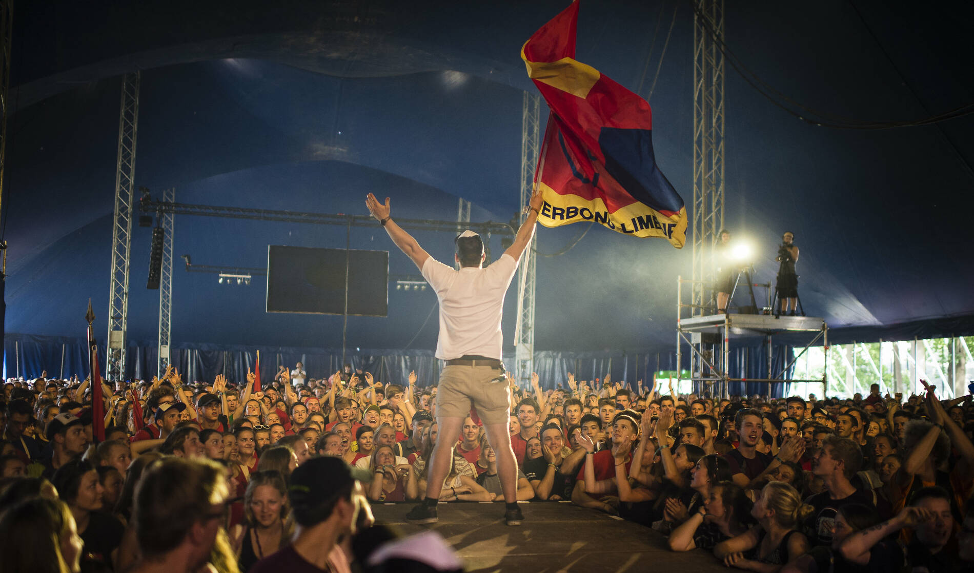 Man met vlag voor massa