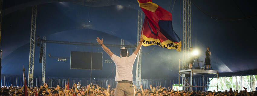 Man met vlag voor massa