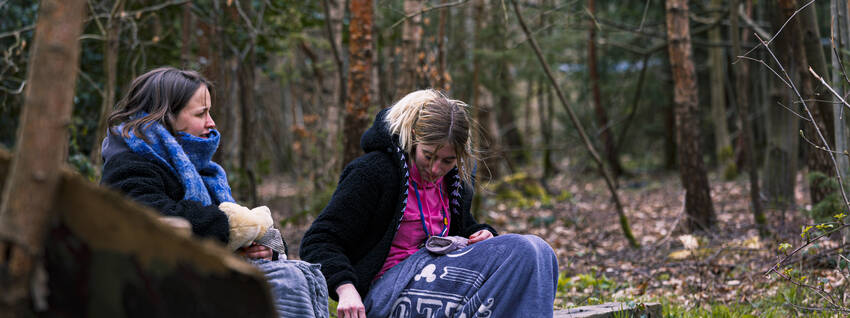 Leidsters zitten met dekentje buiten in het bos