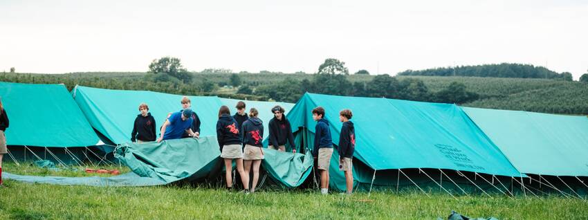 Leden zetten een tent op.