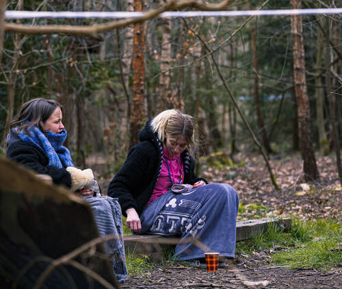 Leidsters zitten met dekentje buiten in het bos