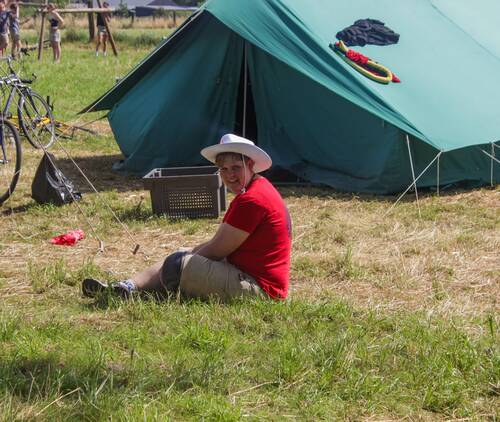 Jongen zit op de grond voor een tent