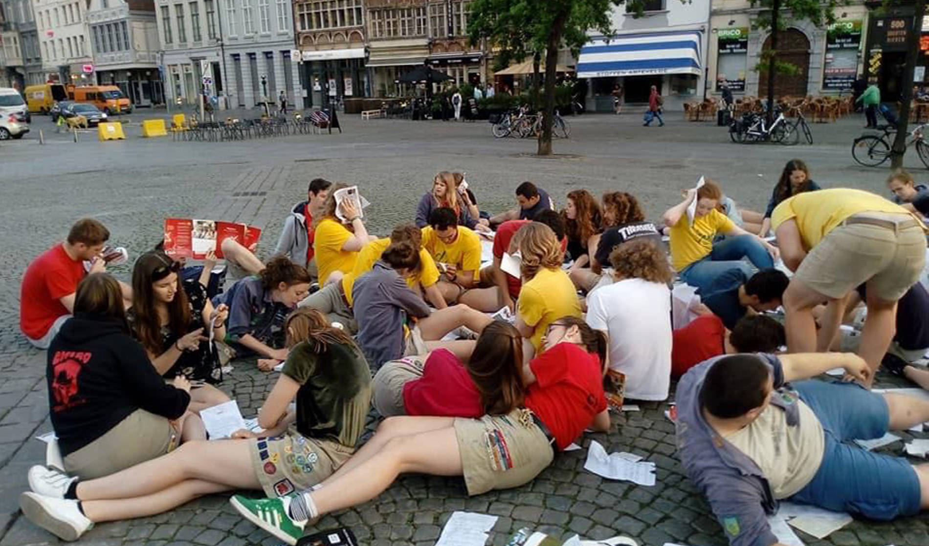 jongeren zitten samen bij elkaar op de grond