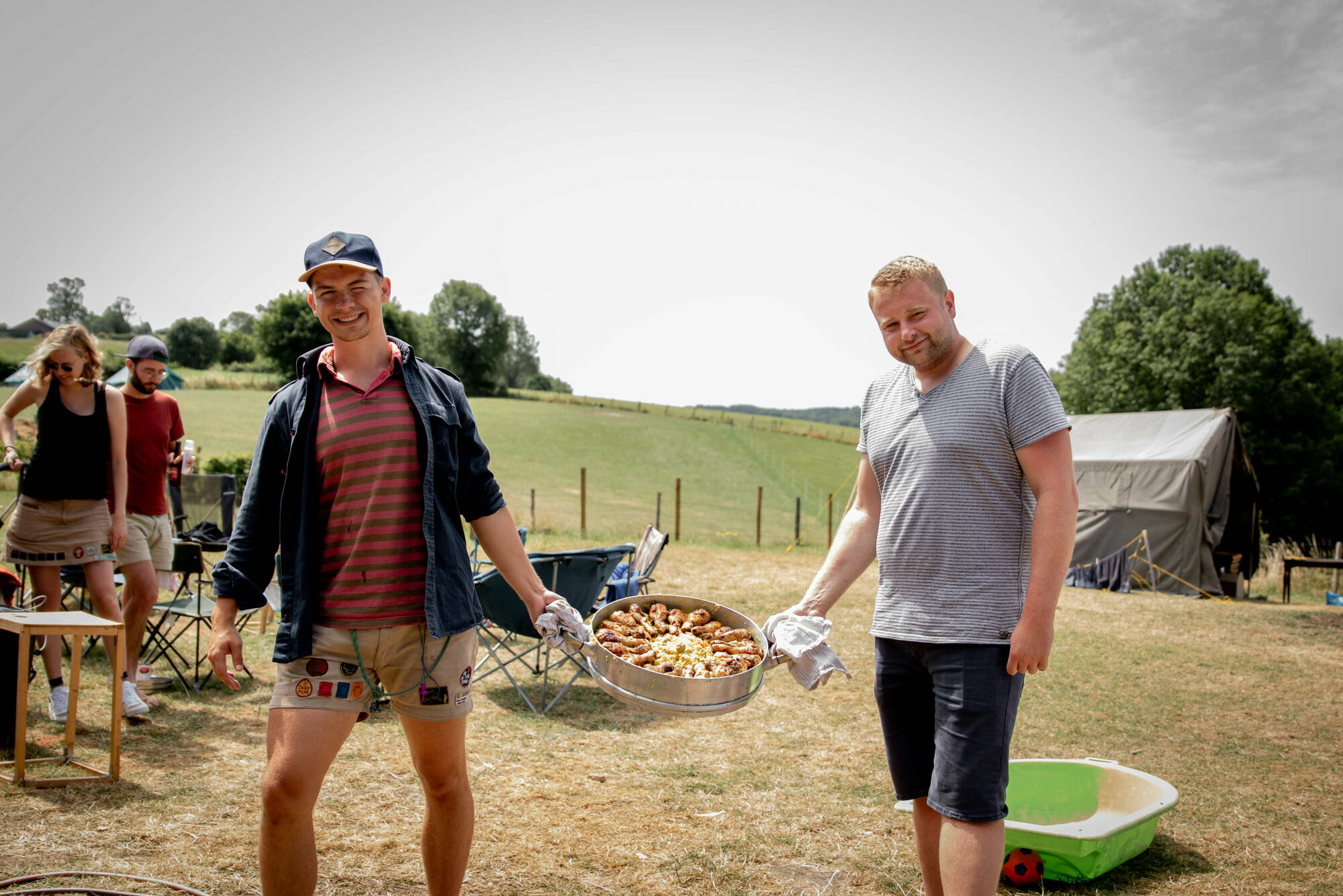 kookouders met een pan eten op kamp